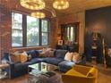 A stylish living room features exposed brick, a large blue sofa, and modern light fixtures at 3180 Mathieson Drive # 502, Atlanta, GA 30305