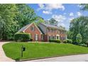 Charming brick home featuring a beautifully manicured lawn and classic architectural details at 6165 Pin Oak Ln, Alpharetta, GA 30005