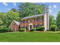 Well-maintained two-story brick home with lush green lawn and meticulously trimmed hedges at 6165 Pin Oak Ln, Alpharetta, GA 30005