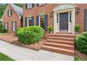 Inviting front entrance featuring brick steps, tasteful landscaping and sconce lighting at 6165 Pin Oak Ln, Alpharetta, GA 30005
