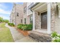 Welcoming front entrance showcasing brick steps, a brown front door, and white trim at 2252 Talmai Dr, Snellville, GA 30078