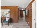 Hallway with wood paneling and modern gray floors, offering a glimpse into other rooms at 389 Oglesby Bridge Se Rd, Conyers, GA 30094