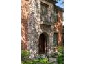 Close-up of the home's stone facade, arched entry and dark wood door and balcony at 612 Concord Lake Se Cir, Smyrna, GA 30082