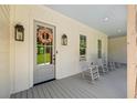 Inviting front porch with rocking chairs, gray painted wood floors and door, and decorative wreath at 115 Trinity Hollow Dr, Canton, GA 30115