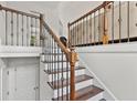 Staircase features wooden stairs, white risers, and iron railing, adding elegance to the home's interior at 4733 Julian Way, Acworth, GA 30101