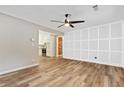 Spacious living room featuring wood floors, elegant wall paneling, and a view of the updated kitchen at 4808 Oak Ct, Ellenwood, GA 30294