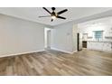 Open living room with wood floors, neutral paint, and a view into the updated kitchen with stainless appliances at 4808 Oak Ct, Ellenwood, GA 30294