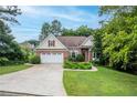 Charming brick home with a manicured lawn, mature trees, and a welcoming two-car garage at 635 Piping Rock Pt, Lawrenceville, GA 30043