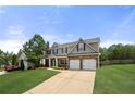 Beautiful two-story home with manicured lawn, stone accents, and a long driveway at 143 Monarch Way, Hiram, GA 30141