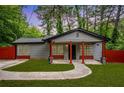 Quaint gray home showcasing a red fence and porch posts, highlighted by a curved walkway and small lawn at 3479 Thompson Dr, Atlanta, GA 30331