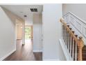 Bright hallway featuring hardwood floors and a staircase with white trim and a wooden banister at 841 Holly Meadow Dr, Buford, GA 30518