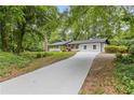 Well-kept white home with a long, newly paved driveway, surrounded by mature trees at 3614 N Druid Hills N Rd, Decatur, GA 30033