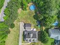 Aerial view of backyard featuring a pool, mature trees and outdoor living space at 385 Eagles Nest Cir, Carrollton, GA 30116