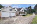 View of home with attached two-car garage and basketball hoop and long driveway at 385 Eagles Nest Cir, Carrollton, GA 30116