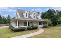 Charming two-story home featuring a covered front porch, mature landscaping, and manicured lawn at 385 Eagles Nest Cir, Carrollton, GA 30116