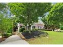 Beautiful brick home featuring manicured landscaping and a paved driveway leading to the welcoming front entrance at 4085 Hillcrest View Ct, Suwanee, GA 30024