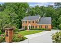 Inviting brick home with a manicured lawn, charming mailbox, and a long driveway at 5524 Wedgewood Sw Ct, Lilburn, GA 30047