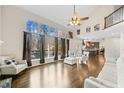 Spacious living room with hardwood floors, a wall of windows, and access to the kitchen at 735 Amberton Close, Suwanee, GA 30024