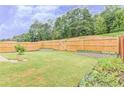 Fenced backyard featuring a well-maintained lawn and simple landscaping at 2385 Mayfair Dr, Cumming, GA 30040