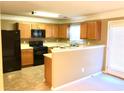 Efficient kitchen with light wood cabinets, black appliances, and a practical layout at 2385 Mayfair Dr, Cumming, GA 30040