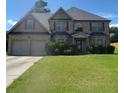 Charming two-story brick home with a well-kept lawn, inviting entryway, and a two-car garage at 4482 Ridge Mill Ne Ter, Douglasville, GA 30135