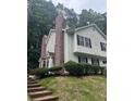 Multi-level home exterior with brick accents, black shutters, and green landscaping at 5425 Village Green Sq, Norcross, GA 30093