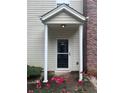 Inviting front entrance with a portico and red flowers adding charm and color at 5425 Village Green Sq, Norcross, GA 30093