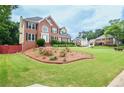 Beautiful brick house with a lush front lawn and well-kept landscaping features at 930 Cedar Bluff Sw Trl, Lilburn, GA 30047
