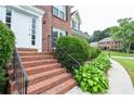 Brick steps lead to a front door with a manicured lawn and bushes at 930 Cedar Bluff Sw Trl, Lilburn, GA 30047