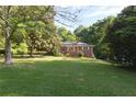 Charming brick home with a welcoming screened-in porch and lush, green lawn at 5670 Lanny Dr, Powder Springs, GA 30127