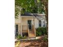 The front porch welcomes visitors to this charming home nestled among mature trees at 5999 Brookside Se Ln, Mableton, GA 30126