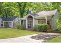 Inviting home with a rocking chair porch, lush lawn, and shaded driveway at 1364 Westboro Sw Dr, Atlanta, GA 30310