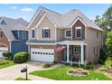 Well-manicured lawn and landscaping accent this two-story home with a two-car garage at 180 Mirramont Lake Dr, Woodstock, GA 30189