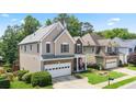 Two-story home with well-kept lawn, two-car garage, and inviting front porch at 180 Mirramont Lake Dr, Woodstock, GA 30189