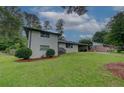 View of a charming white brick two-story home with green front yard, trees, and shrubs at 2324 Ithica Se Dr, Marietta, GA 30067