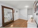 Welcoming foyer with hardwood floors, a white door, a decorative mirror, and a glimpse of the staircase at 2324 Ithica Se Dr, Marietta, GA 30067