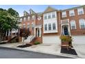 A row of brick townhouses featuring two-car garages, landscaped yards and brick stairs at 4855 Payson Se Ter # 3, Atlanta, GA 30339