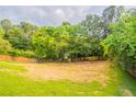 The backyard features a large grassy area, enclosed by a wooden fence and mature trees at 5696 Glandor Dr, Mableton, GA 30126