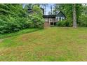 Green home with large front lawn, wooden deck, and beautiful surrounding greenery at 1033 Justice Nw Ln, Acworth, GA 30102