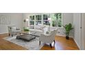 Bright living room with hardwood floors, stylish furniture, and large windows offering views of the lush greenery at 225 River Springs Dr, Sandy Springs, GA 30328