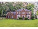 Traditional brick home with manicured lawn and mature landscaping at 214 Jamestown Ave, Jonesboro, GA 30236
