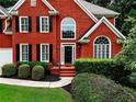 Close up shot of a brick home featuring a manicured lawn and mature landscaping at 1850 Noblin Ridge Way, Duluth, GA 30097