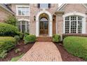 Charming brick walkway leading to an arched entryway with a stately wooden front door at 314 Caruso Ct, Sandy Springs, GA 30350