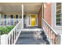 The front porch is highlighted by a bright yellow door and steps leading up to it at 4817 Overland Dr, Powder Springs, GA 30127