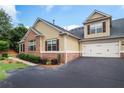 Two-story home featuring a two-car garage, lush landscaping, and classic brick and siding exterior at 1585 Oak Meadows Ln, Cumming, GA 30041