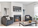 Cozy living room with a stone fireplace, decorative art, plush seating, and natural light from the window at 6001 Pine Bluff Pl, Conyers, GA 30013