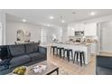 Open-concept living space with kitchen island seating, a comfortable couch, and a seamless flow to the dining area at 6001 Pine Bluff Pl, Conyers, GA 30013