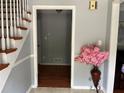 Inviting foyer with staircase, hardwood floors, and a decorative vase of pink flowers at 1159 Aurora Ct, Atlanta, GA 30338