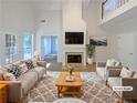 Bright living room with a cozy fireplace, high ceilings, and stylish neutral furniture at 132 Lynnview Ct, Mcdonough, GA 30252