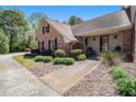 Brick home's entryway with a concrete walkway, manicured bushes, and Adirondack chairs on a porch at 1935 Northbrooke Ln, Dunwoody, GA 30338